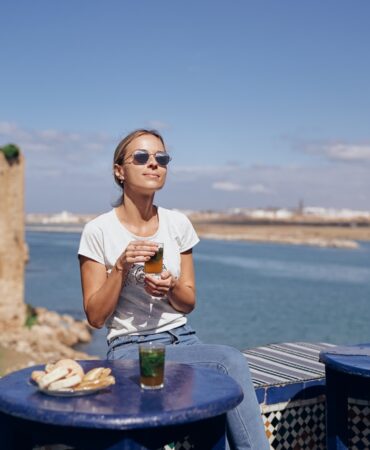 A,Woman,In,Sunglasses,Enjoys,A,Drink,At,An,Outdoor A,Woman,In,Sunglasses,Enjoys,A,Drink,At,An,Outdoor